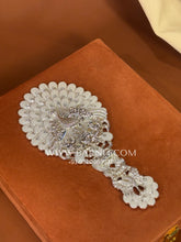 Back view of the silver handheld mirror with intricate floral craftsmanship