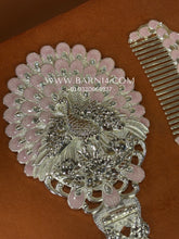 Close-up of the silver handheld mirror featuring detailed floral craftsmanship