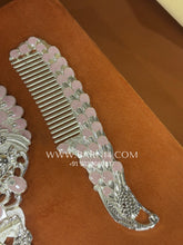 Close-up of the handcrafted silver comb with decorative floral handle