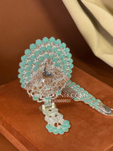 Silver mirror with floral detailing and matching comb displayed upright in a decorative set