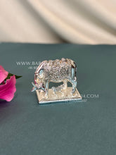Pure silver cow with calf standing beside it