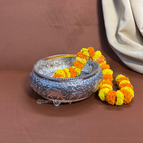 Handcrafted metal urli with detailed carvings and elephant patterns, symbolizing prosperity and harmony.