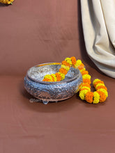 Handcrafted metal urli with detailed carvings and elephant patterns, symbolizing prosperity and harmony.