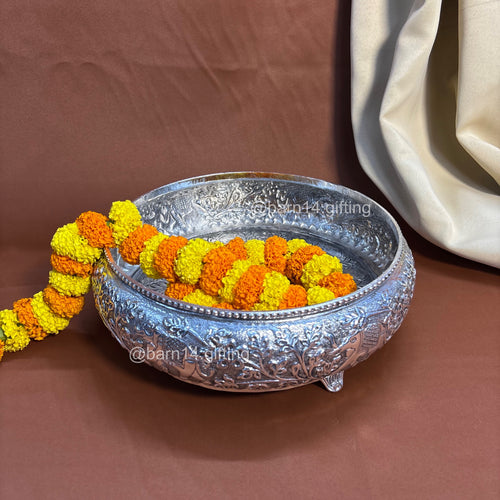 Handcrafted metal urli with detailed carvings and elephant patterns, symbolizing prosperity and harmony.