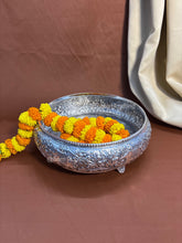 Handcrafted metal urli with detailed carvings and elephant patterns, symbolizing prosperity and harmony.