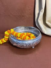 Handcrafted metal urli with detailed carvings and elephant patterns, symbolizing prosperity and harmony.