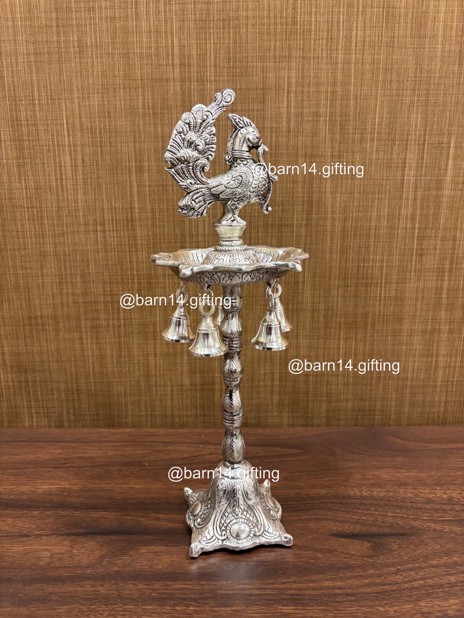Silver finish five wick peacock diya stand with hanging bells, traditional lamp for Diwali, pooja, and festive rituals, symbol of prosperity and devotion.