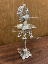 Silver finish five wick peacock diya stand with hanging bells, traditional lamp for Diwali, pooja, and festive rituals, symbol of prosperity and devotion.