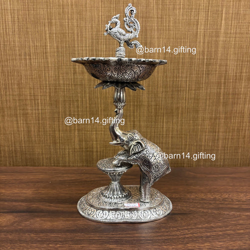Silver finish Gaj Mayur diya stand with elephant base and peacock finial, traditional lamp for Diwali, housewarming, and daily pooja rituals.