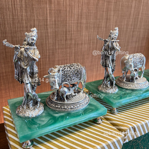 Handcrafted Krishna idol playing flute with cow, set on vibrant green base, radiating love and blessings, ideal for festive, spiritual, and traditional gifting.