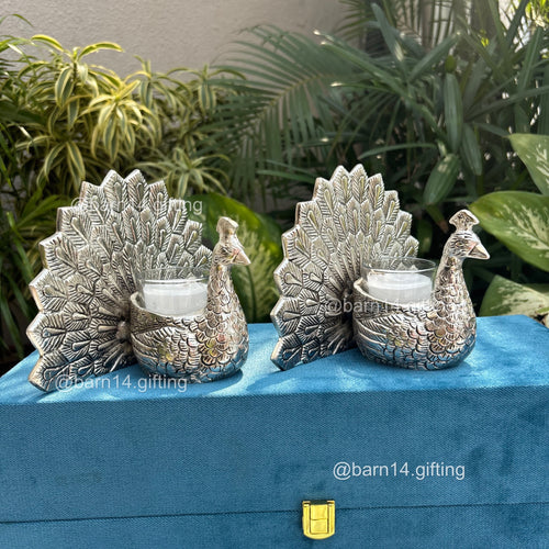 Elegant peacock design glass candle in silver finish – luxury gifting piece for Diwali, weddings, anniversaries, and corporate celebrations.