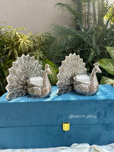 Elegant peacock design glass candle in silver finish – luxury gifting piece for Diwali, weddings, anniversaries, and corporate celebrations.