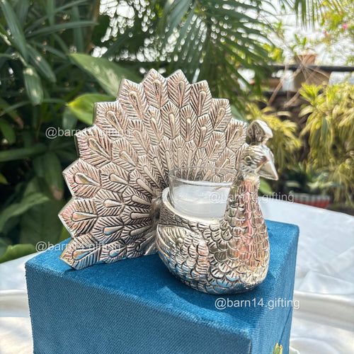 Elegant peacock design glass candle in silver finish – luxury gifting piece for Diwali, weddings, anniversaries, and corporate celebrations.
