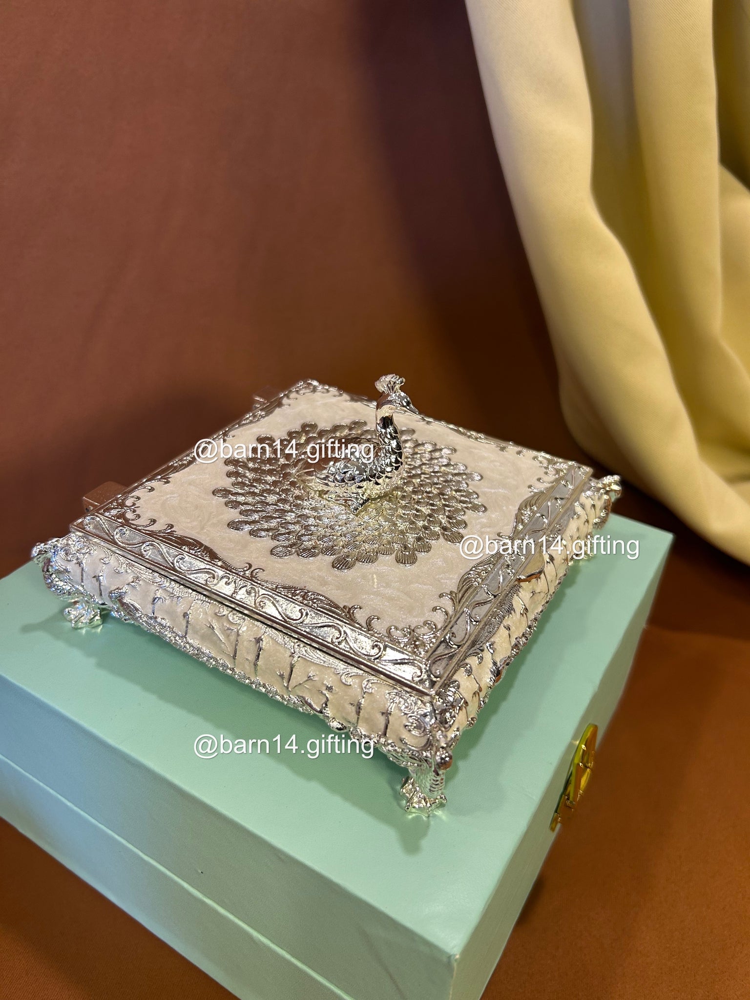 Premium enamel dry fruit box with ornate silver finish and peacock top, luxurious centerpiece and memorable gift for Diwali, weddings, anniversaries, and corporate celebrations.