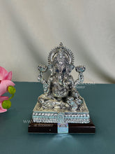 Pure Silver Mangal Ganesh idol seated on wooden base.